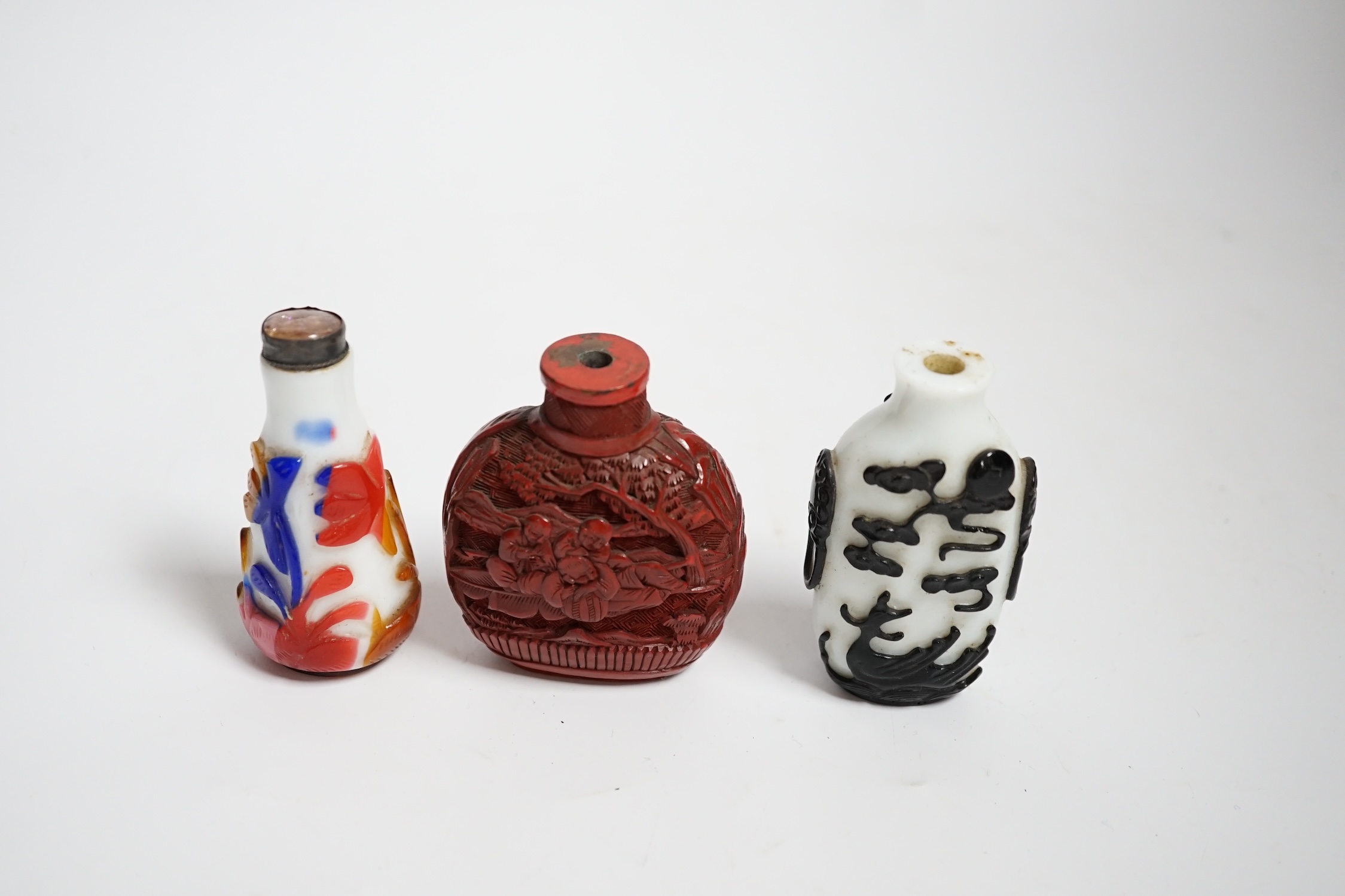 Three Chinese snuff bottles including a 19th century cinnabar lacquer ‘boys’ snuff bottle, largest 7cm high